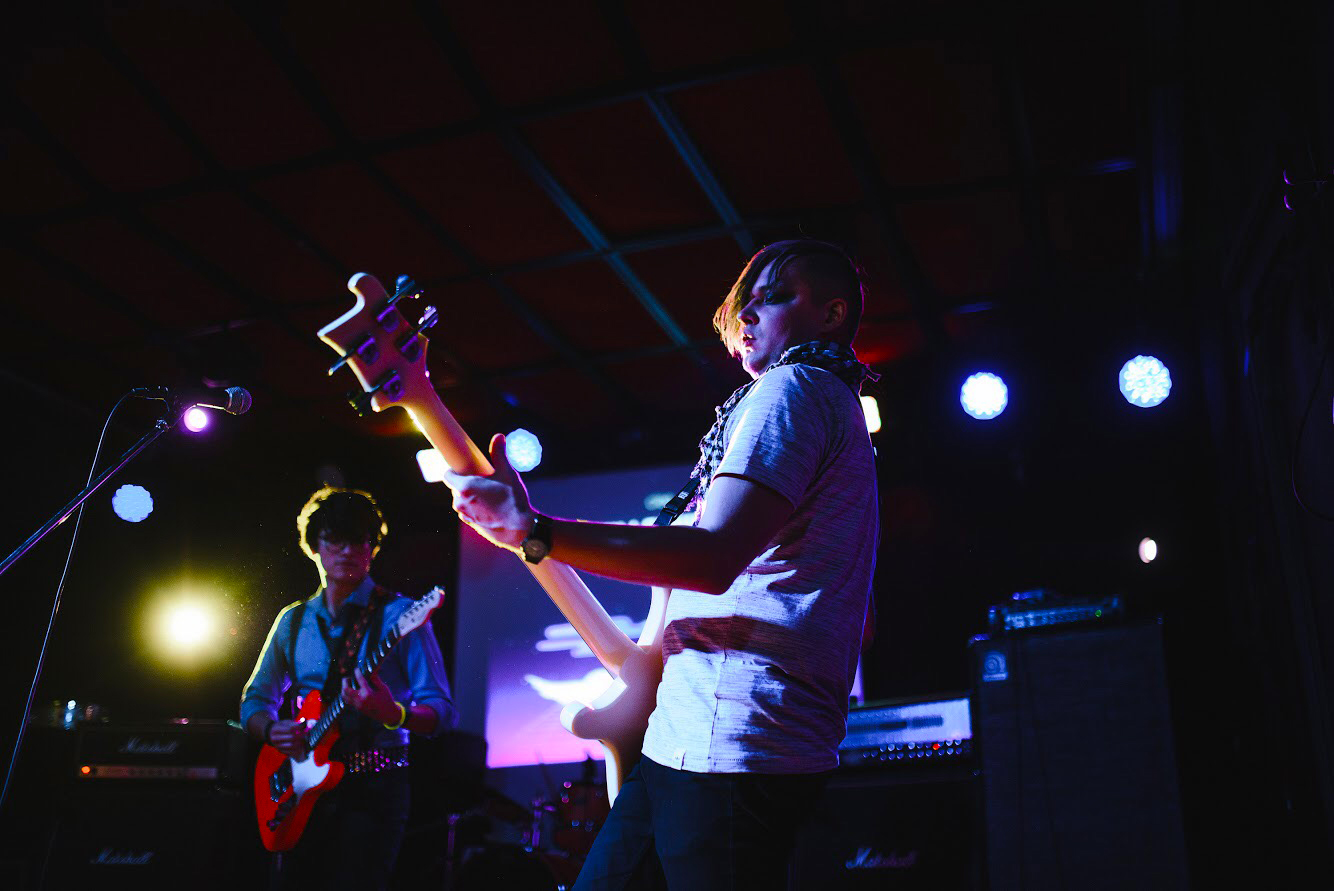 Lallana and another individual playing guitar on stage at a concert.