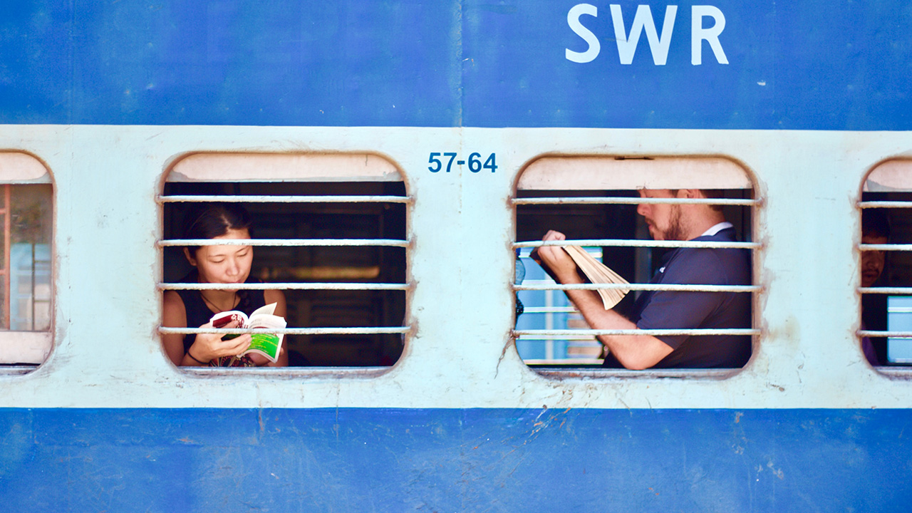 Photo of student on a blue and white train reading
