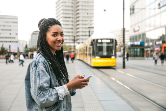 Image of global learning student smiling on the sidewalk of a busy European city.