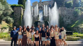 Students standing in front of a large fountain in Rome, Italy