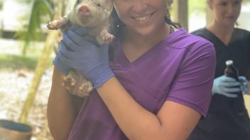 stduent holding a baby pig