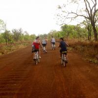 Teaser image of students on a bike riding down a dirt road - Click to learn more about this program