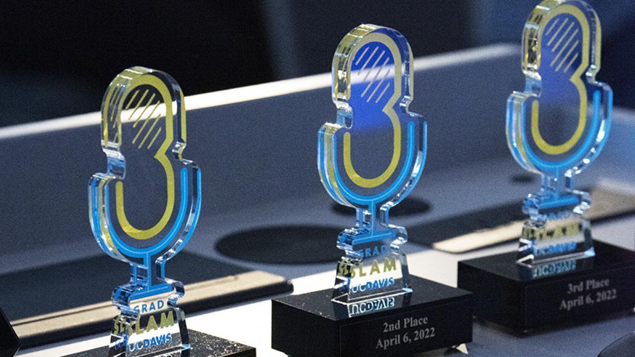 Three 2022 Grad Slam trophies are lined up next to each other at an angle.