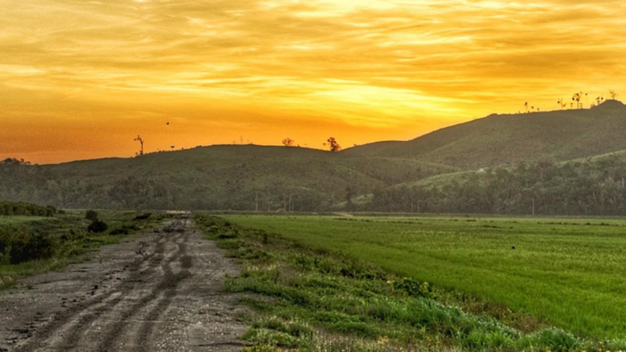photo of a landscape with rolling hills and sunset sky