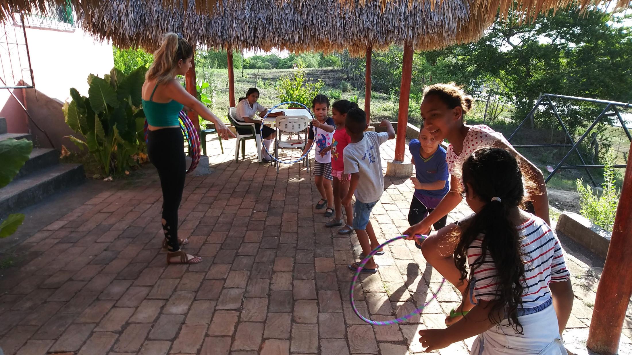 A fellow Blum fellow explaining relay races with hula hoops at the end of the reading palooza before the caponera (motorcycle with bench) came to take the kids home.