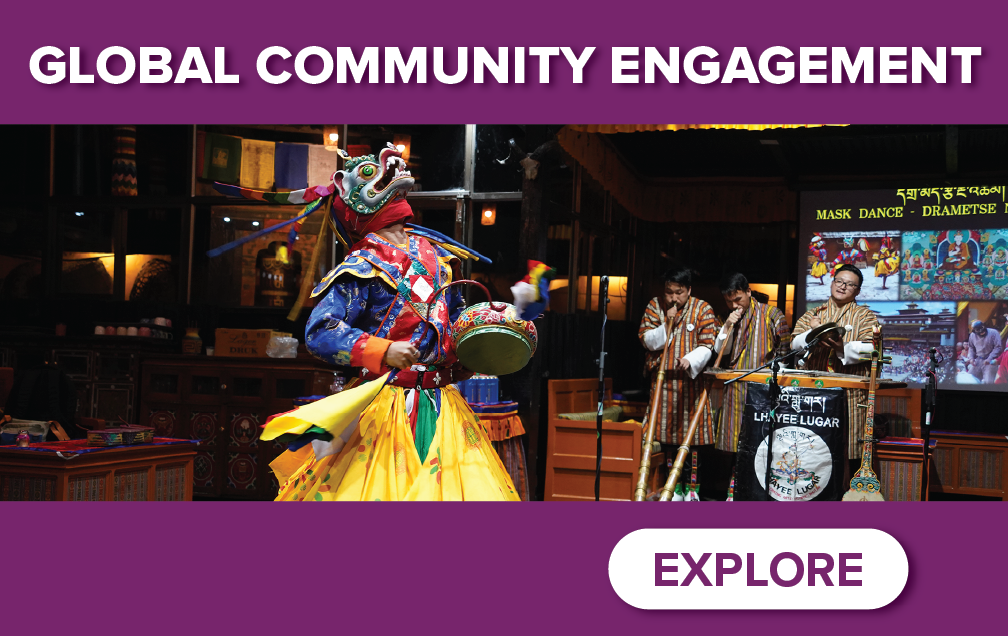 A colorful performer in traditional attire dances on stage while three musicians play instruments. The banner reads "Global Community Engagement" with an "Explore" button at the bottom.