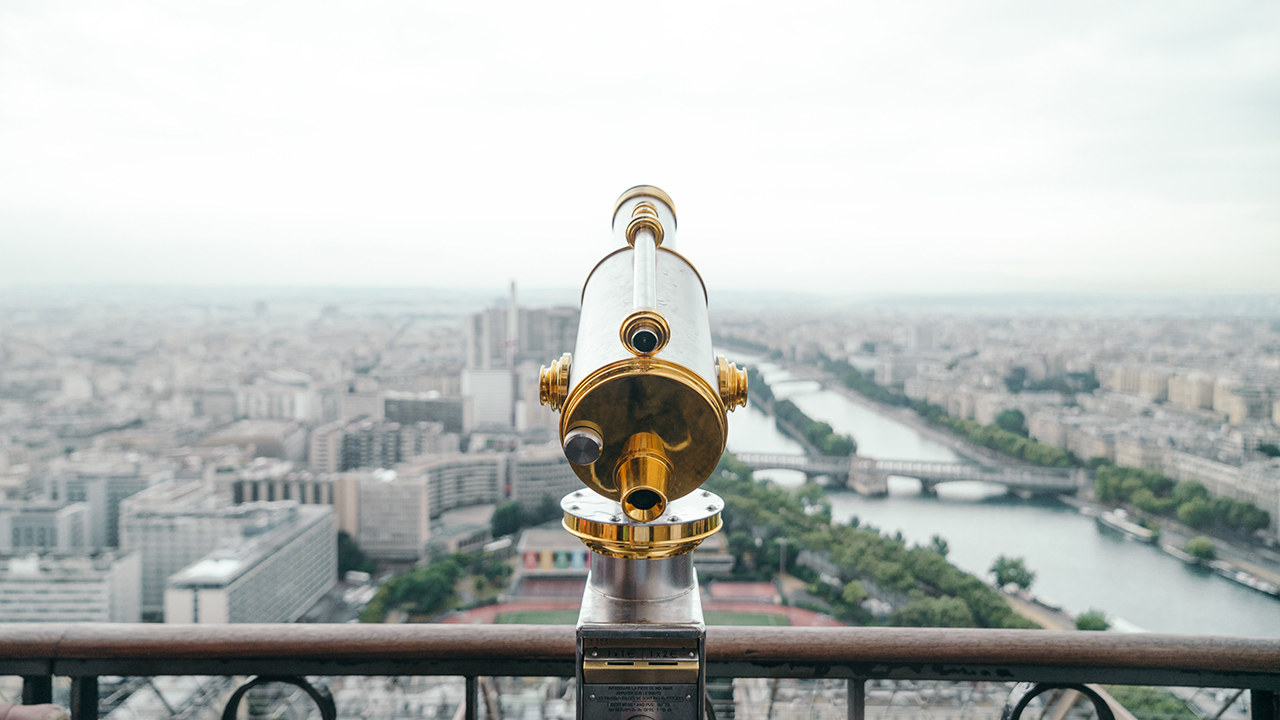 Image of a telescope atop a large building overlooking a city