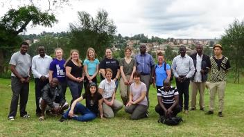 A group of student on the program taking a photo on green pastures in Uranda