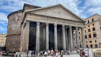 Students walking around in front of an iconic building in Rome, Italy