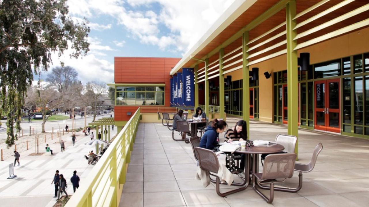 Photo of a building on campus. Students are studying at a table.