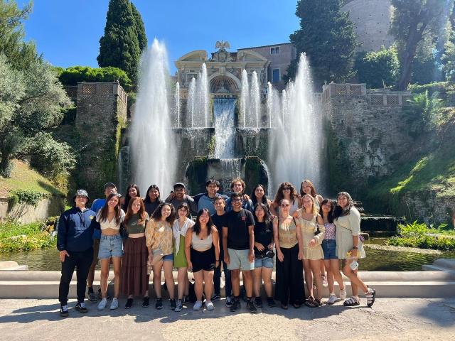 Students standing in front of a large fountain in Rome, Italy