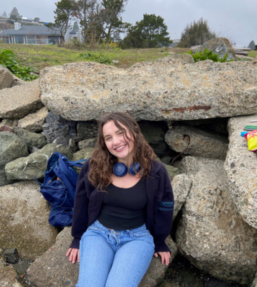 Monet Lahn sitting on rocks smiling.