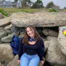 Monet Lahn sitting on rocks smiling.