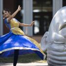 Vyoma dances in a blue skirt next to an Egghead.