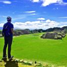 A student atop Monte Alban in Oaxaca, Mexico. A beautiful blue sky dominates his view.