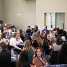 Students sitting at tables in a larger multi-purpose room