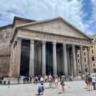 Students walking around in front of an iconic building in Rome, Italy