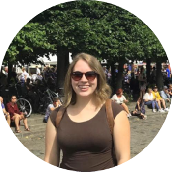 Student in sunglasses standing in front of a tree