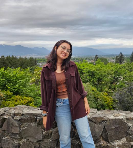 Student standing in front of a lookout point with trees in the background
