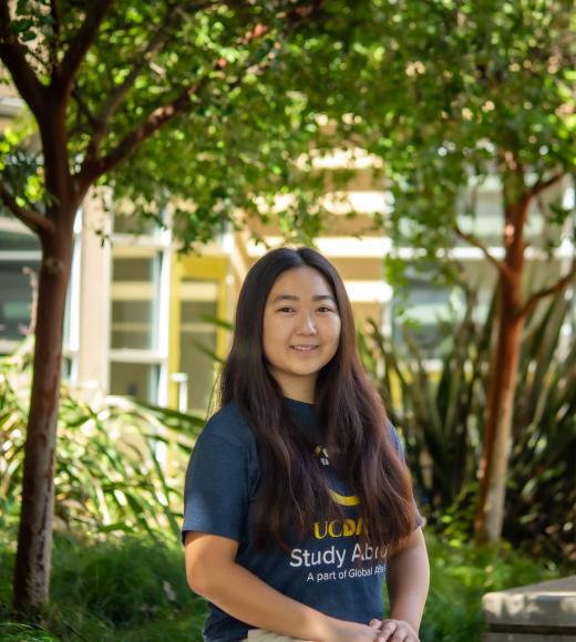 Crystal smiling in front of trees for headshot.