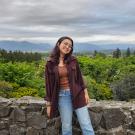 Student standing in front of a lookout point with trees in the background